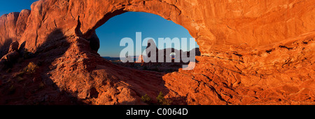 A panoramic image of Turret Arch as seen through North Window at sunrise, Arches National Park, Utah, USA. Stock Photo