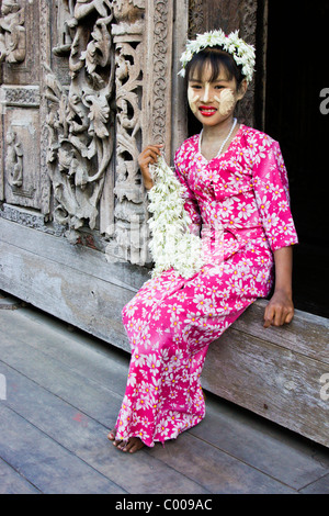 Girl with thanaka on face selling flowers, Shwenandaw Kyaung, Mandalay, Myanmar (Burma) Stock Photo