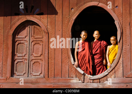 Young Buddhist monks in window of Shwe Yan Pye monastery, Inle Lake, Myanmar (Burma) Stock Photo