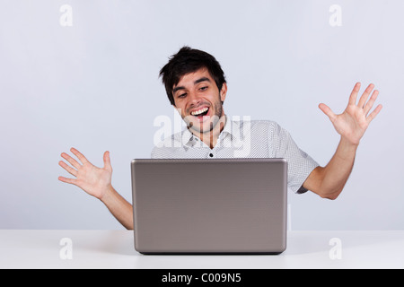 young man surprised and happy with something he see on his laptop Stock Photo