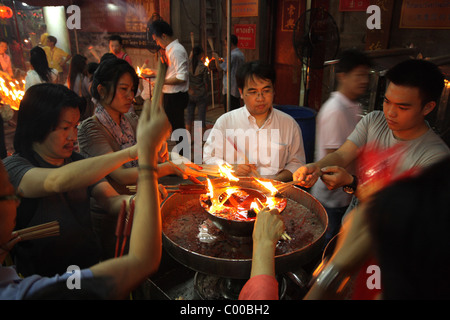 Thai people light incense sticks at a Chinese temple in Bangkok , Chinese New Year Festival Stock Photo
