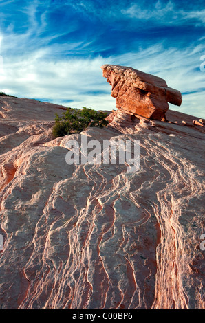 A lone balancing rock sits atop this sandstone plateau in Nevada's Valley of Fire State Park. Stock Photo