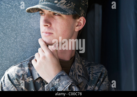 Young man in army combat uniform thinking Stock Photo