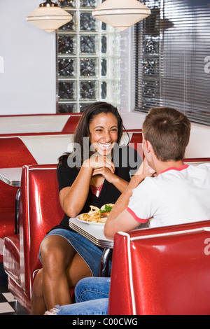 Teenage interracial couple having lunch in a diner