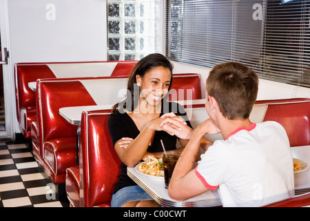 Teenage interracial couple having lunch in a retro diner