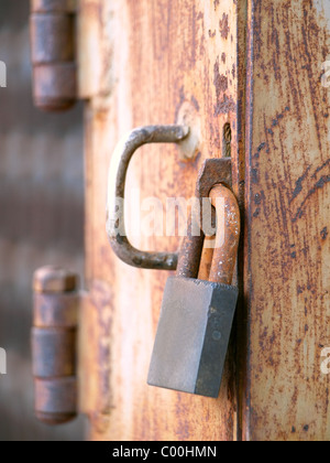 Rusty old padlock on an iron door Stock Photo