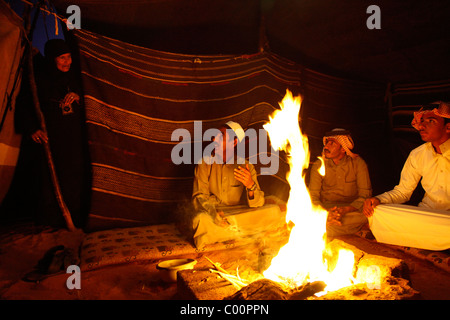 Bedouins sitting around the fire in their camp, Wadi Rum, Jordan. Stock Photo