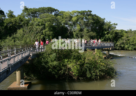 Tourists on raised walkway over [Rio Iguazu] near Garganta del Diabolo [Devil's Throat] at [Iguassu Falls] Stock Photo