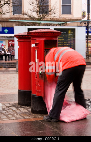 A postman is collecting mail in city district london stock photo A postman is collecting mail in city district london stock photo