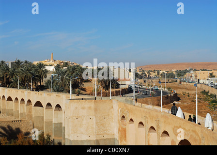 Algeria, Ghardaia, people walking on bridge with vehicles on the move on winding road Stock Photo