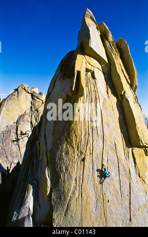 Male rock climber clinging to a cliff. Stock Photo