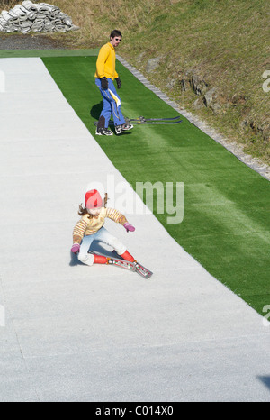 A young child falls over on a dry Ski slope in Plymouth Devon England Stock Photo