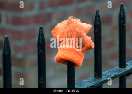 A lost glove placed on park railings. Stock Photo