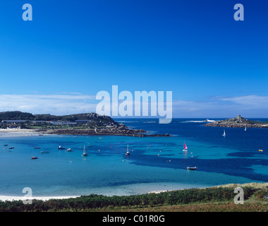 Clear blue sea surrounds the island of Tresco, Isles of Scilly, UK. Old Grimsby harbour and the Island Hotel in midsummer Stock Photo