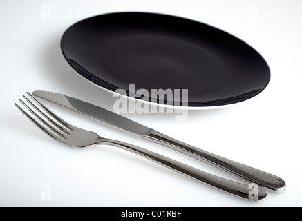 Empty black plate with knife and fork Stock Photo