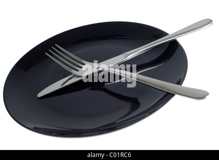Empty black plate with knife and fork on white background Stock Photo