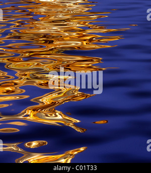 Gold-colored reflection on the water, background Stock Photo