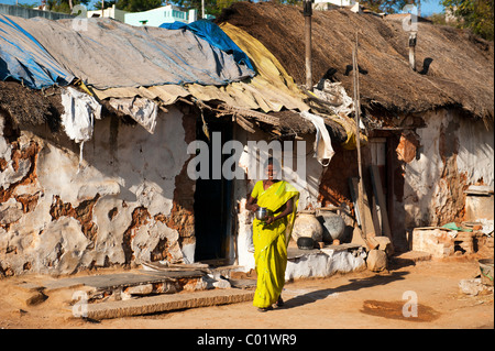 Indian woman coming out of her rural indian village house. Karnatikanagapalli, Andhra Pradesh, India Stock Photo