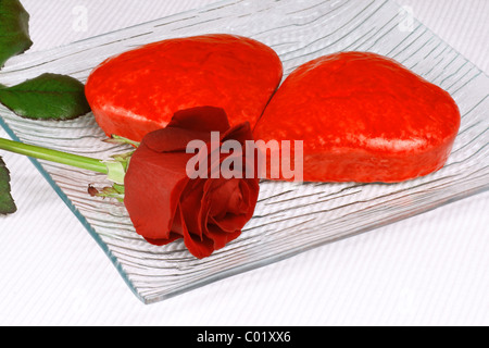 Two red heart shaped cakes and a rose for Valentine's Day Stock Photo