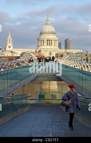 Pedestrians on Millennium Bridge, crossing the River Thames, taken from Bankside looking to St Pauls Cathedral,  London, England Stock Photo