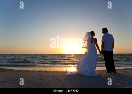 Wedding of a married couple, bride and groom, together at sunset on a beautiful tropical beach Stock Photo