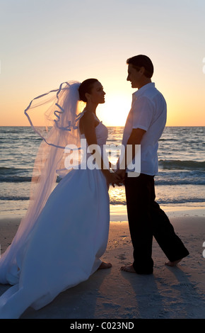 Wedding of a married couple, bride and groom, together at sunset on a beautiful tropical beach Stock Photo