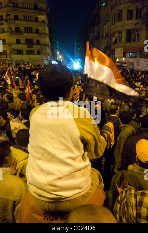 boy waving flag and anti-Mubarak protestors at Tahrir Square, Cairo, Egypt Stock Photo