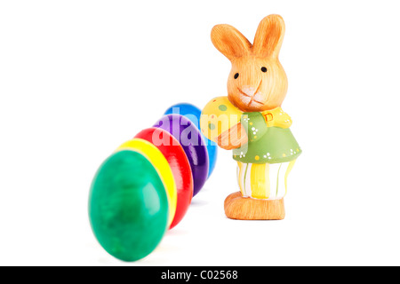 easter bunny figurine in front of deep row of easter eggs on white background Stock Photo