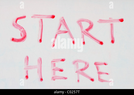 start here written in red dry erase marker on a used white board Stock Photo