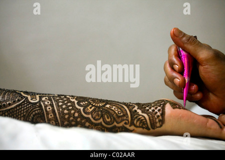 And Indian bride with traditional henna (aka mehndi) paint covering her arms and hands at her wedding day in New Delhi in India. Stock Photo