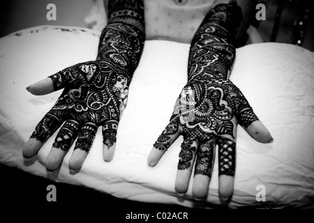 And Indian bride with traditional henna (aka mehndi) paint covering her arms and hands at her wedding day in New Delhi in India. Stock Photo