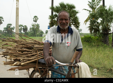 A firewood seller carrying a load of wood on his bicycle, Jaffna Sri Lanka Stock Photo