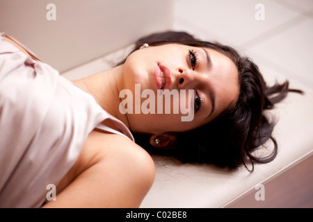 Young woman lying on a sofa and relaxing Stock Photo