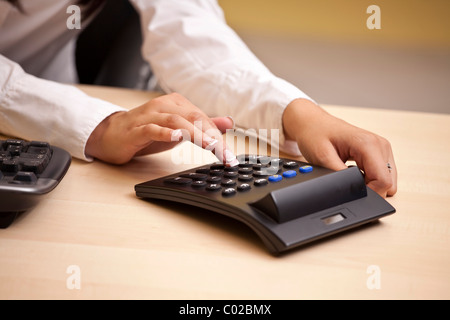 Young woman using on calculator Stock Photo