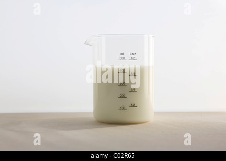 Measuring cup with milk Stock Photo