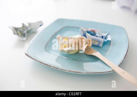 Banknotes on a plate, symbolic picture for food costs Stock Photo