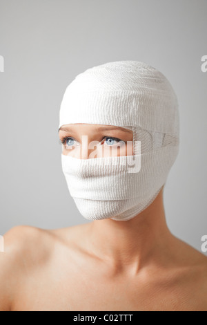 a woman with her head wrapped in a bandage Stock Photo