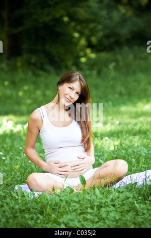 pregnant woman seats  touching stomach Stock Photo