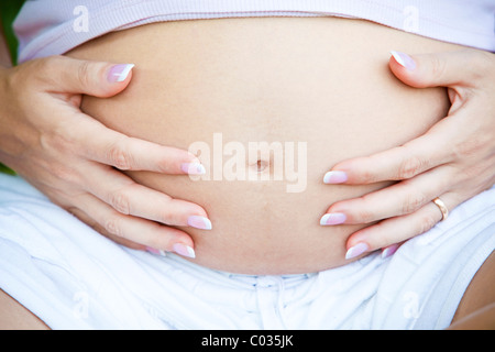 pregnant woman touching stomach Stock Photo