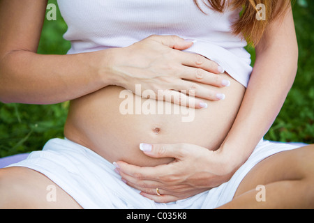 pregnant woman touching stomach Stock Photo