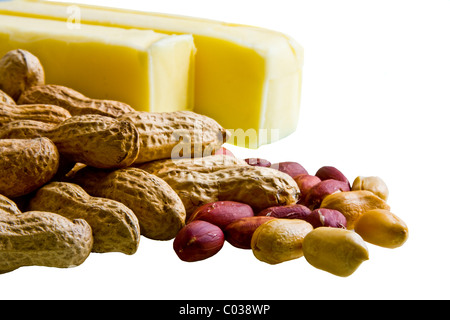 Closeup of peanuts in and out of shell with bars of butter on white background Stock Photo