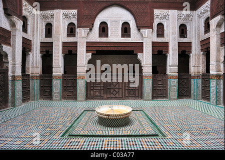 Partial view, courtyard of the Medersa Bou Inania, walls with cedar wood carvings, stucco decorations and tile mosaics, Meknes Stock Photo