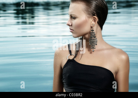 Young woman in a black bathing suit and with wet hair, bathing in a lake Stock Photo