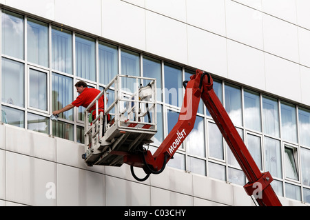 Building cleaner on a boom lift cleaning the windows of Neuss Courthouse, Lower Rhine, North Rhine-Westphalia, Germany, Europe Stock Photo