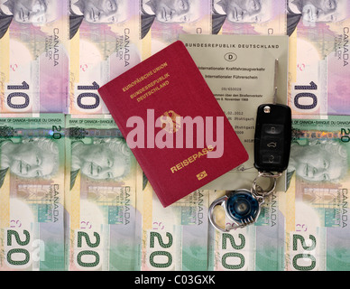 Passport of the Federal Republic of Germany, an international driving license and a car key on various Canadian dollar bills Stock Photo