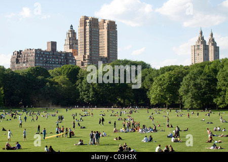People sunbathing in Central Park in front of skyscrapers, Manhattan, New York, USA Stock Photo