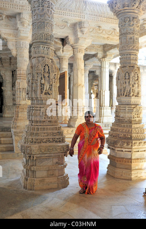 Indian woman wearing a traditional sari in the inner hall with ornate marble pillars in the Temple of Ranakpur Stock Photo