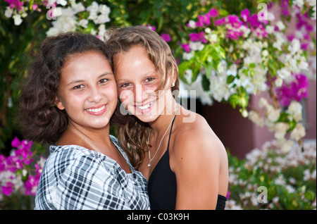 Portrait of two thirteen-year-olds girls in front of flowers Stock Photo