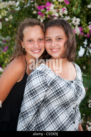 Portrait of two thirteen-year-olds girls in front of flowers Stock Photo