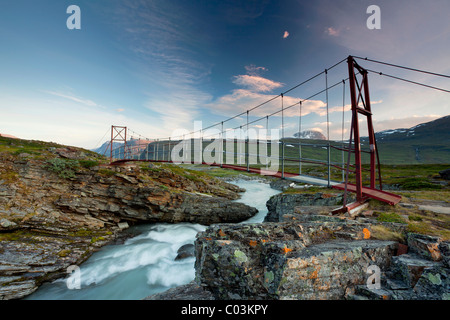 Midnight sun and an old suspension bridge in the Tjaekta Valley, Kungsleden, The King's Trail, Lapland, Sweden, Europe Stock Photo